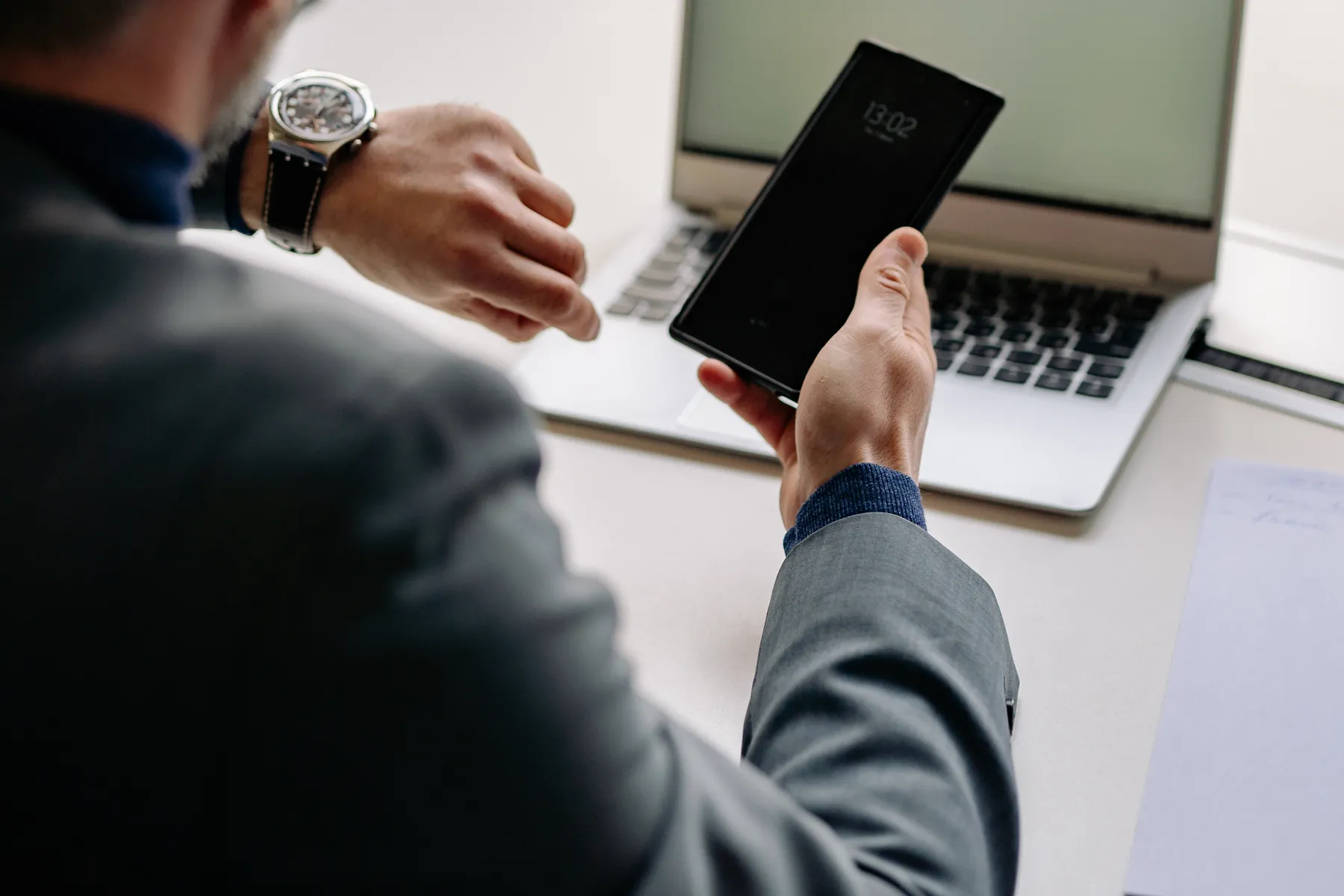 Profissional consulta o horário no celular, ilustração do controle de ponto em empresas terceirizadas.