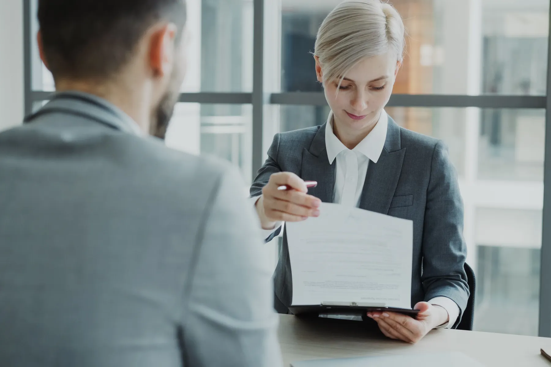 Profissionais revisam documentos financeiros em imagem ilustrativa sobre reajuste de contratos terceirizados.